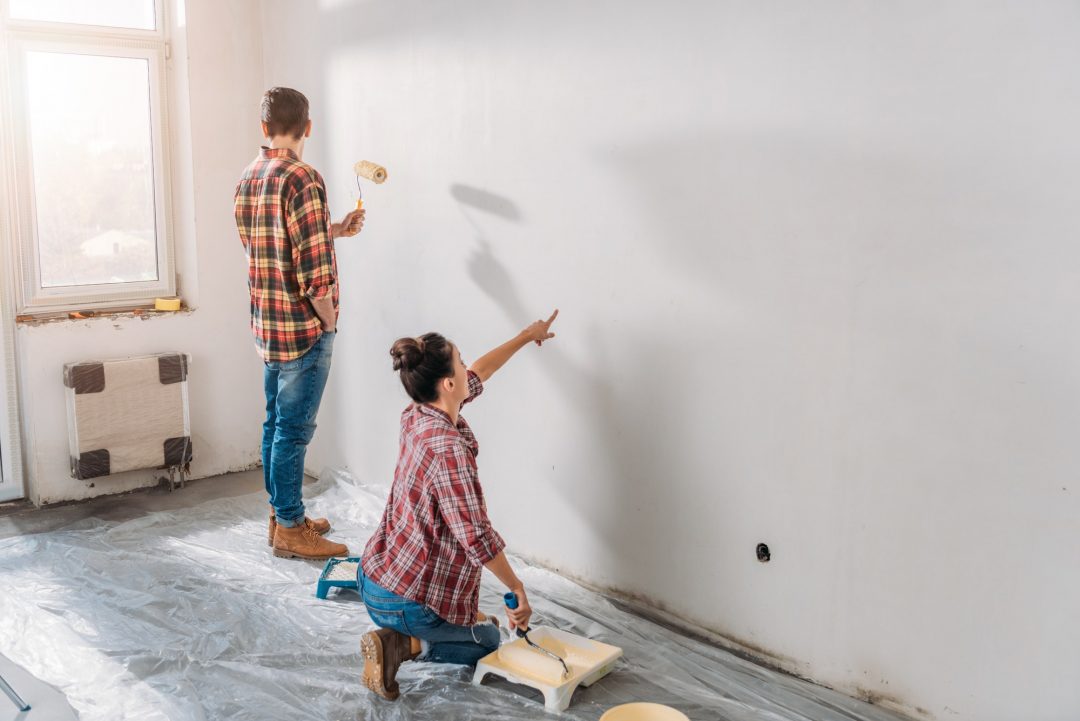 Homeowners painting a freshly plastered wall