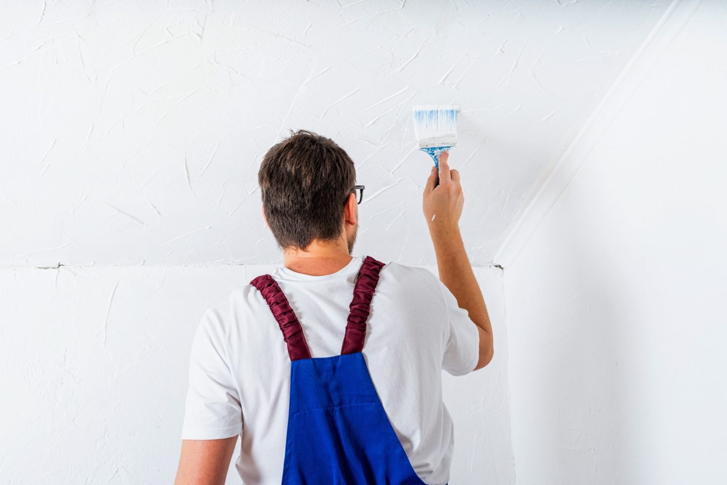 Painter applying enamel polish finish to a wooden door frame